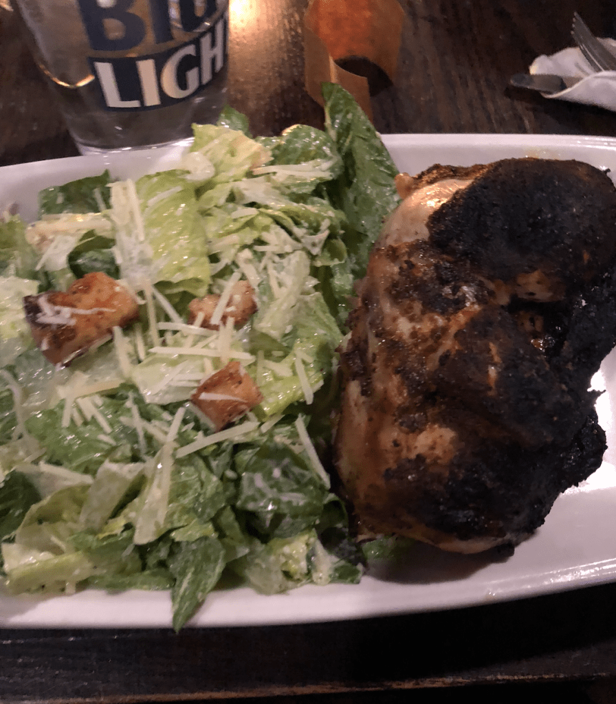 image description: my plate of a caesar's salad and a chicken on the bone