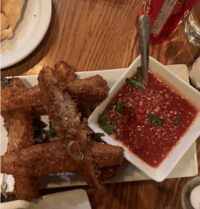 image description: eggplant french fries on a plate beside a bowl of marinara sauce.