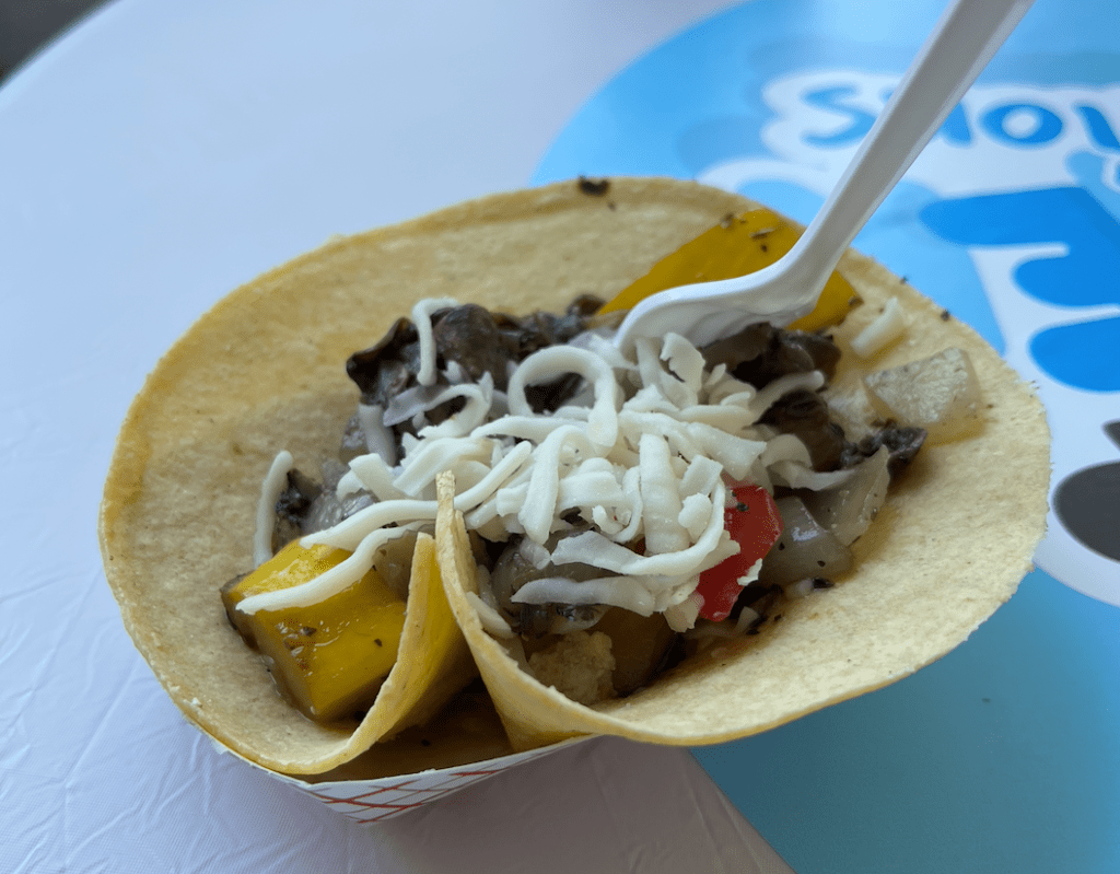 a mixture of cheese and vegetables in a taco shell