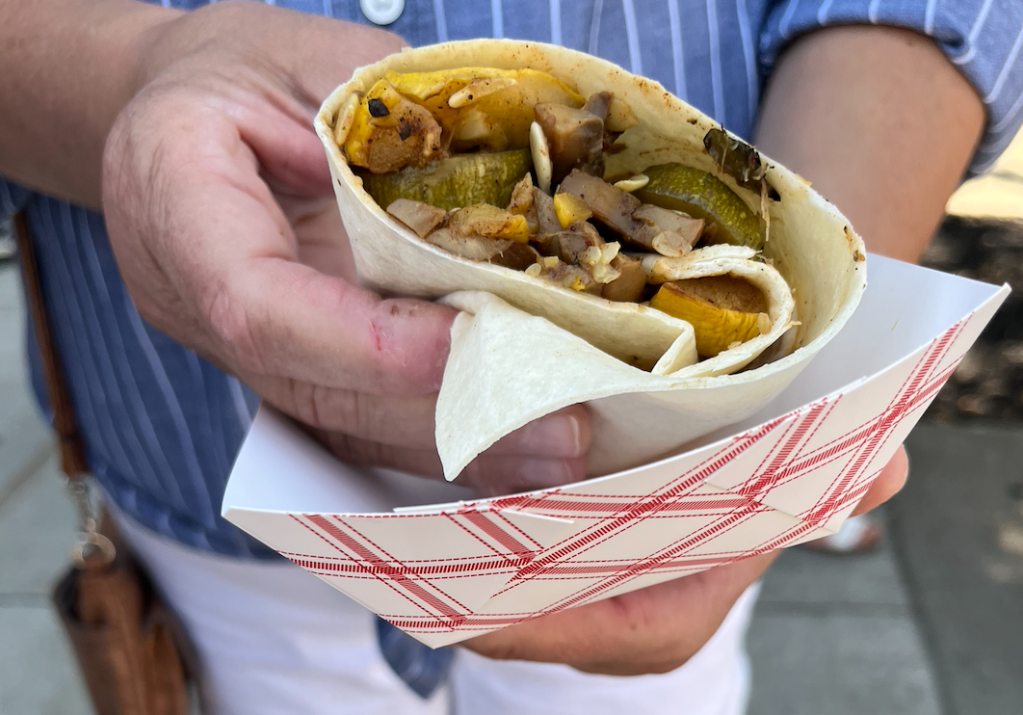 my mom holds mixed vegetables in a grilled wrap